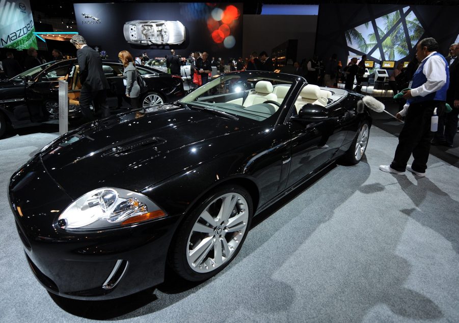 A worker dusts a black 2010 Jaguar XKR Convertible at the 2009 LA Auto Show