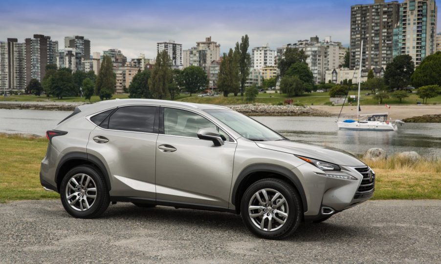 A gold 2022 Lexus NX parked in front of a city.