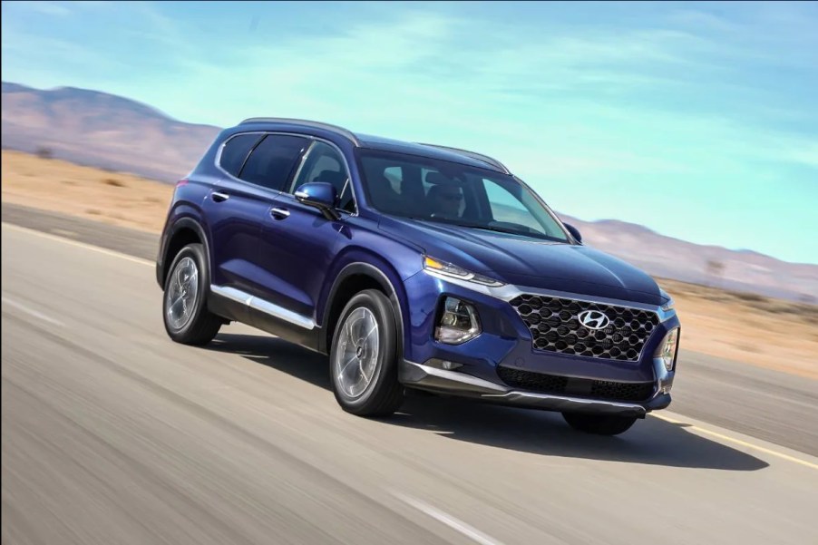 A blue 2019 Hyundai Santa Fe driving outside.