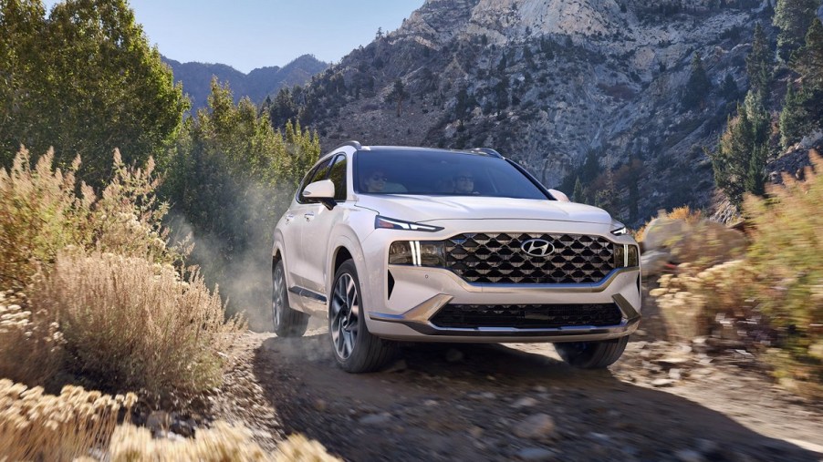 A white 2021 Hyundai Santa Fe in the woods.