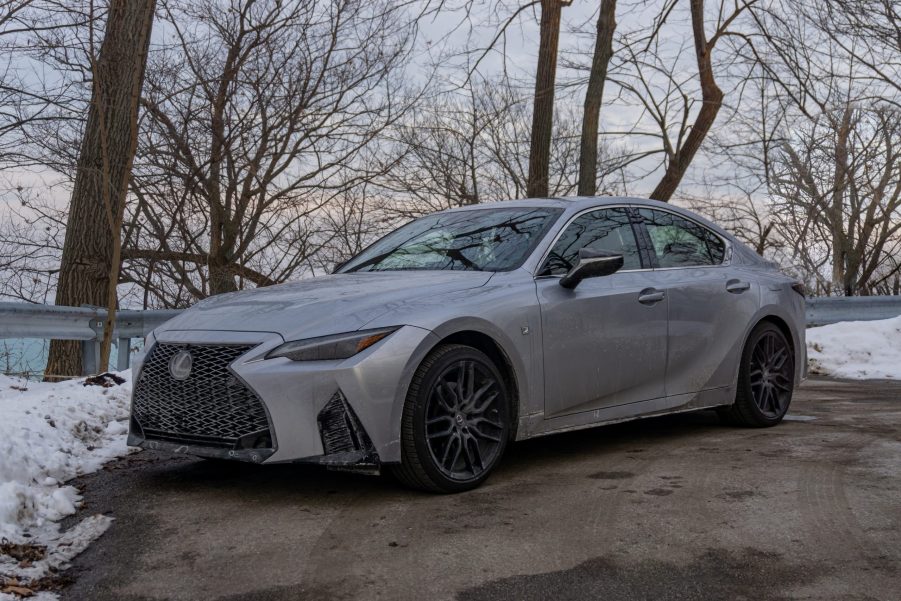 A silver 2021 Lexus IS 350 F Sport AWD with Dynamic Handling Package next to a snowy forest