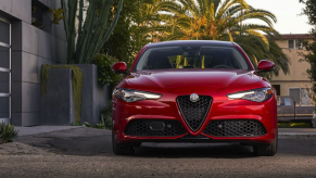 The 2022 Alfa Romeo Giulia luxury sports sedan in red parked near tropical trees