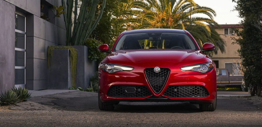 The 2022 Alfa Romeo Giulia luxury sports sedan in red parked near tropical trees