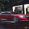 A 2022 red Honda Accord drives down a wet and rain covered city street