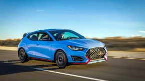 The 2022 Hyundai Veloster N performance hatchback speeding down a highway