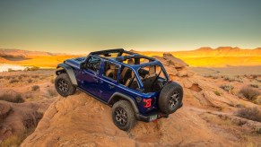 Purple Jeep Wrangler 4x4 SUV parked on a mountaintop.