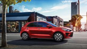 A red 2022 Kia Rio 5-Door in a downtown environment.