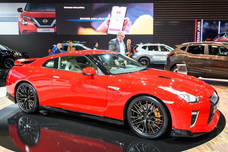 A 2022 Nissan GT-R available as a 2022 Nissan GT-R Nismo in orange at an expo indoors.