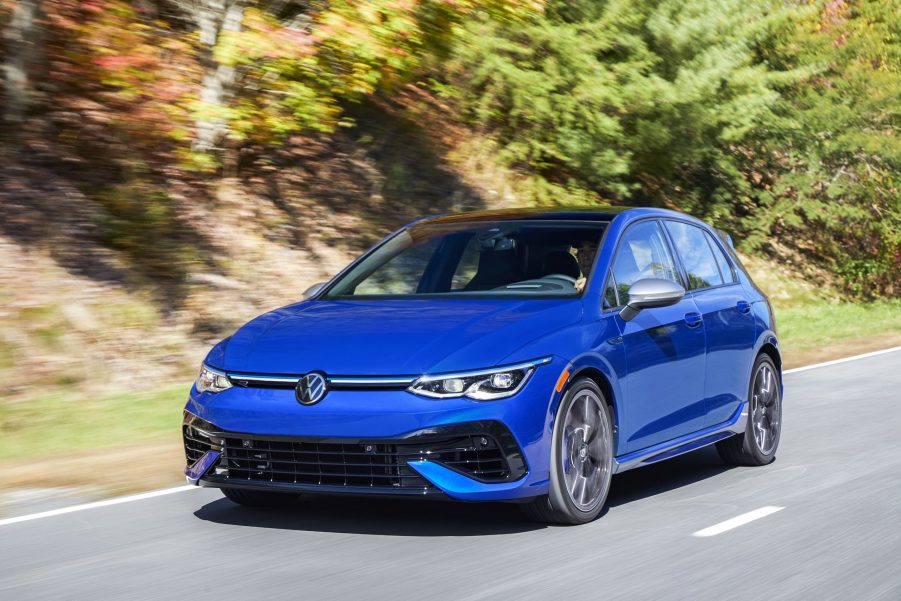 A blue 2022 Volkswagen Golf R driving down a forest canyon road