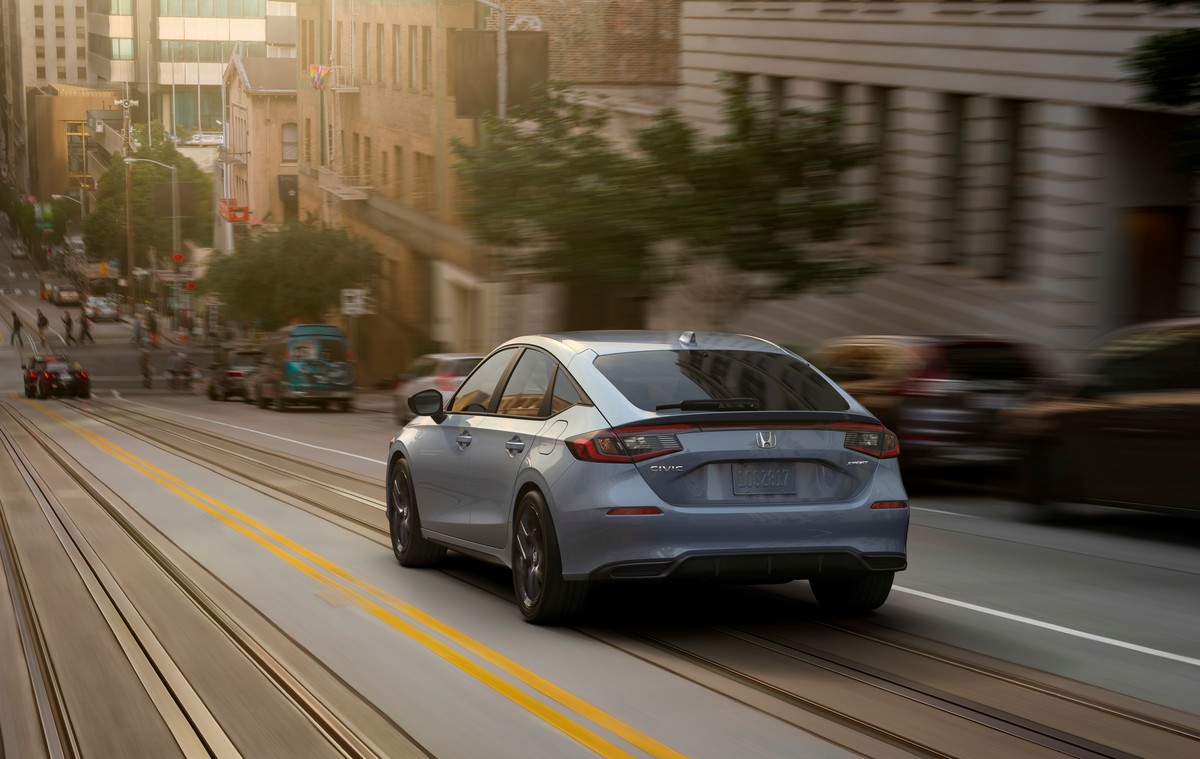 2022 Honda Civic Sport Touring hatchback model driving down a city street