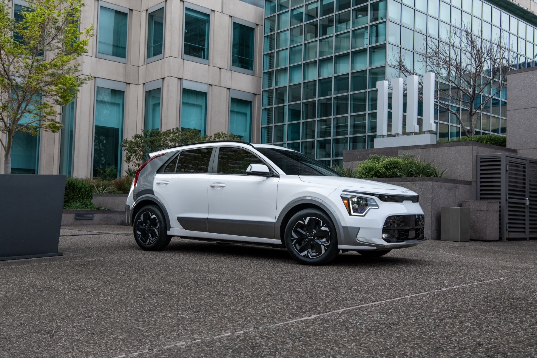 The redesigned 2023 Kia Niro EV compact SUV in white parked on a city rooftop