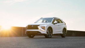 Promo photo of the new 2023 Mitsubishi Eclipse Cross compact SUV parked on concrete in front of a setting sun.