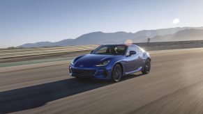 A blue 2023 Subaru BRZ speeding on a racetrack