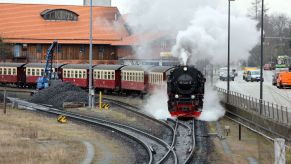 A red and cream train, with a train horn, coming down the tracks