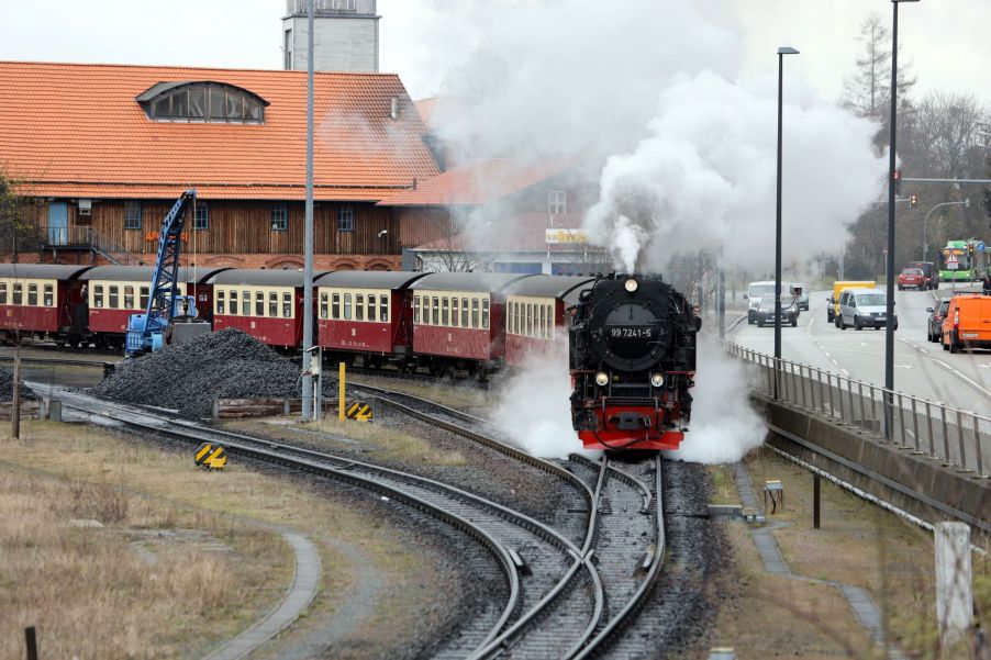 A red and cream train, with a train horn, coming down the tracks