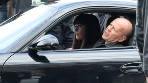 Bruce Willis filming a movie scene, driving a porsche sports car.