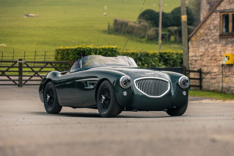 A dark-green Caton Austin-Healey 100 restomod on a British countryside track