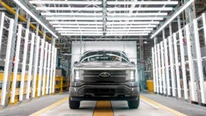 A gray 2022 Ford F-150 Lightning electric pickup truck is parked.