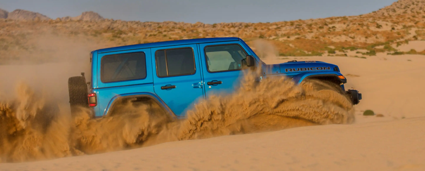 The Jeep Wrangler Rubicon 392 off-road all-terrain SUV driving through sand dunes