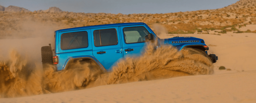 The Jeep Wrangler Rubicon 392 off-road all-terrain SUV driving through sand dunes