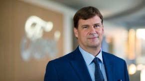 Jim Farley in front of the Ford emblem.