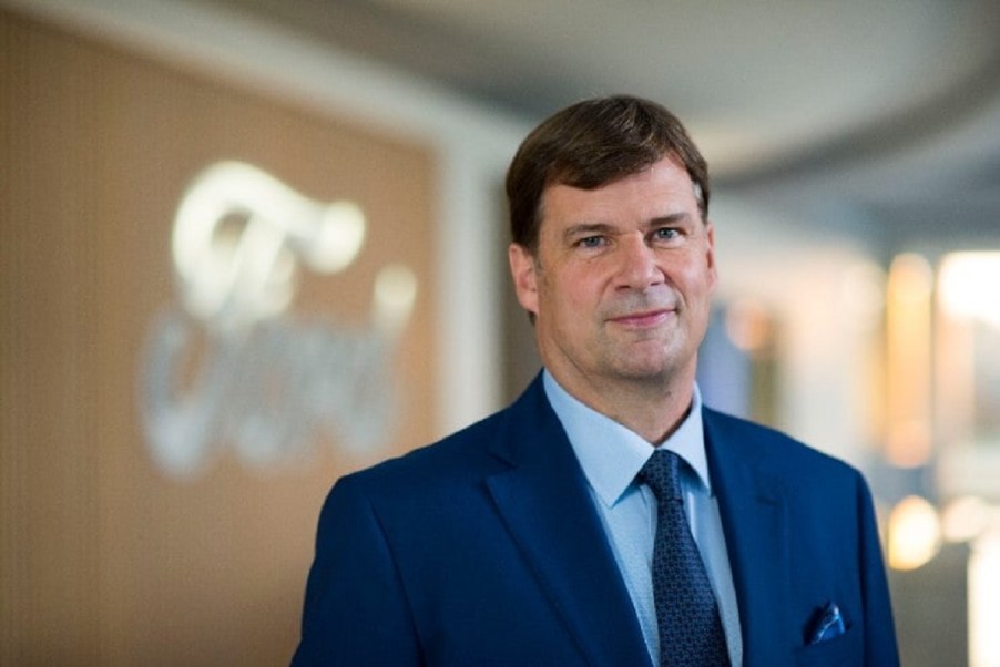 Jim Farley in front of the Ford emblem.