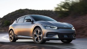 A grey 2022 Kia EV6 cruises on a remote road as an EV crossover.