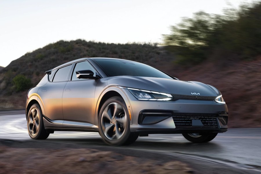 A grey 2022 Kia EV6 cruises on a remote road as an EV crossover.