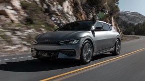 A grey 2022 Kia EV6 cruises along a mountain road.