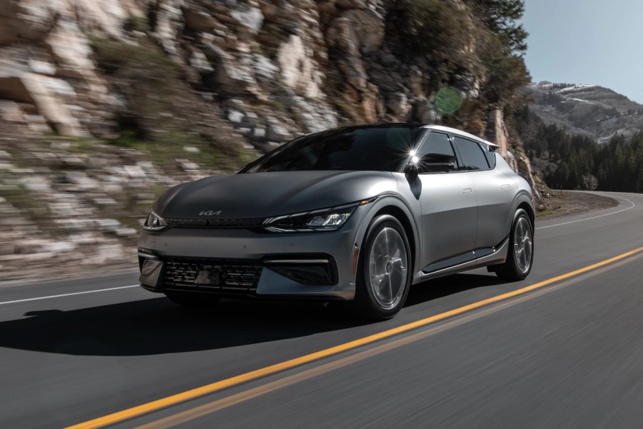 A grey 2022 Kia EV6 cruises along a mountain road.