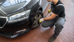 a man torques lug nuts on a wheel with a torque wrench