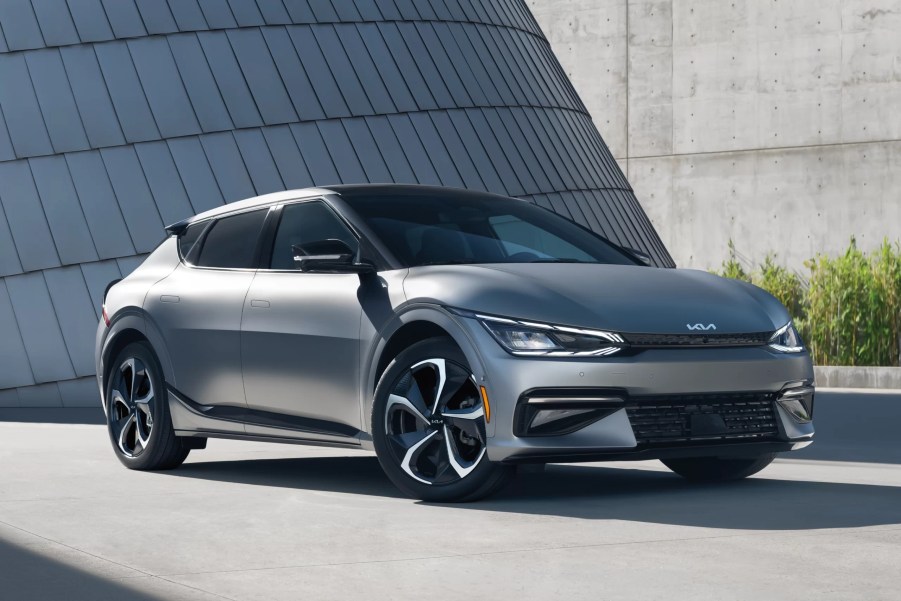 A grey 2022 Kia EV6 shows off its unique design in front of a concrete building.