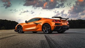 Orange 2023 Chevrolet Corvette shot from rear driver side in clouds