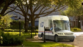 The 2023 Oshkosh NGDV sits in a local neighborhood, as a 2023 USPS mail truck, it is the new face of USPS.