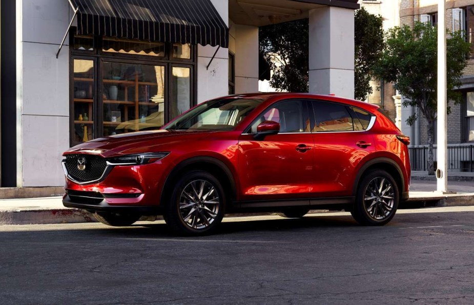 Soul Red Crystal Metallic 2022 Mazda CX-5 parked by a sidewalk