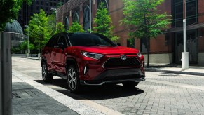 A red Toyota RAV4 Prime plug-in hybrid SUV is parked.