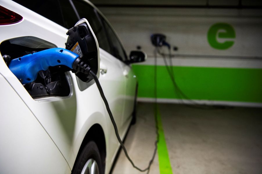 A Toyota vehicle connected to an electric vehicle charging station, which is one of the best EV accessories to have