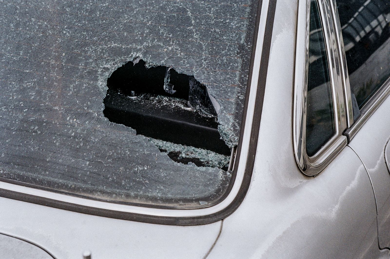 Huge hole with spiderweb cracks in the back windshield of an unidentified car. The hail storm in Florida caused significant damage