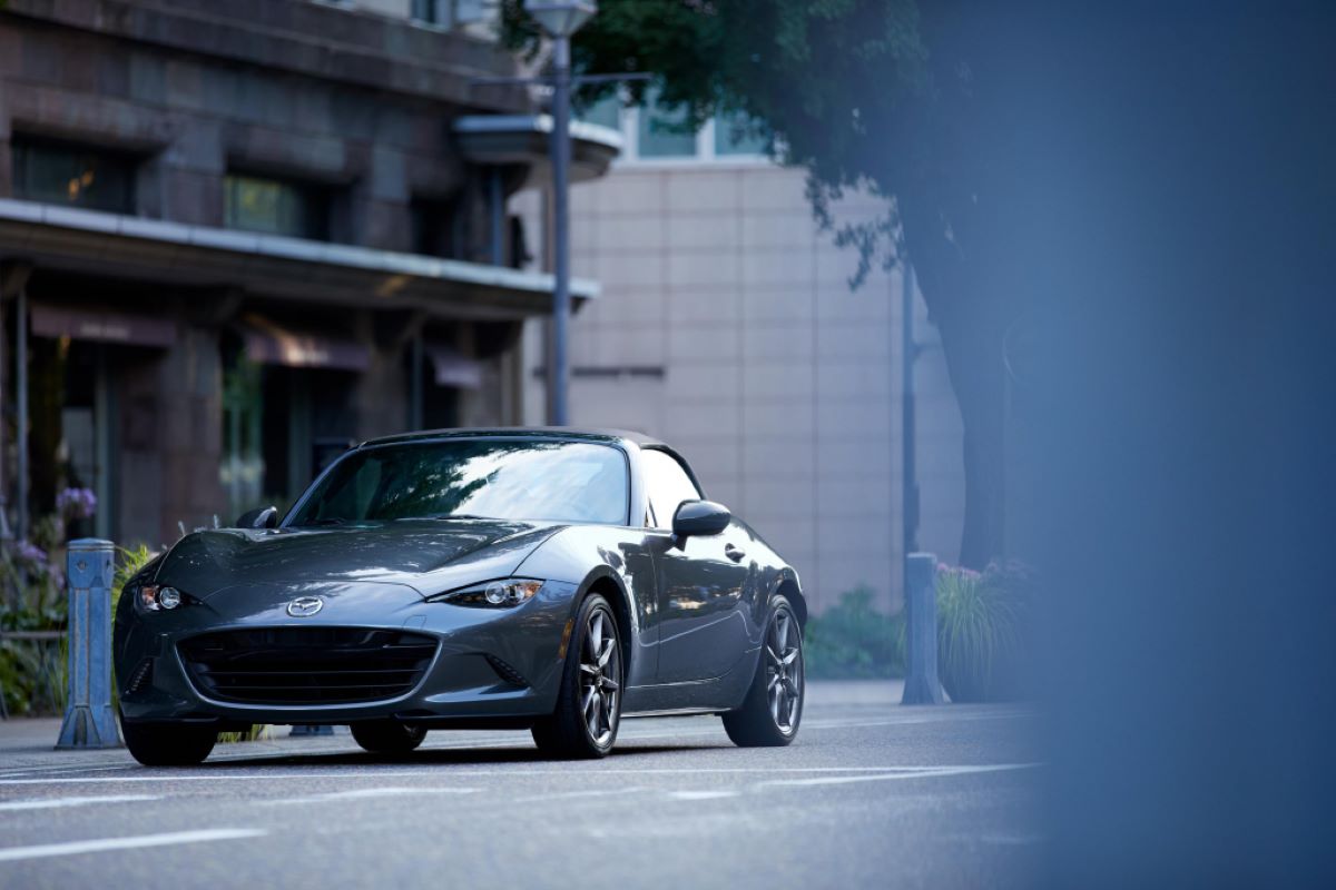 Grey Mazda Miata parked on an empty city street