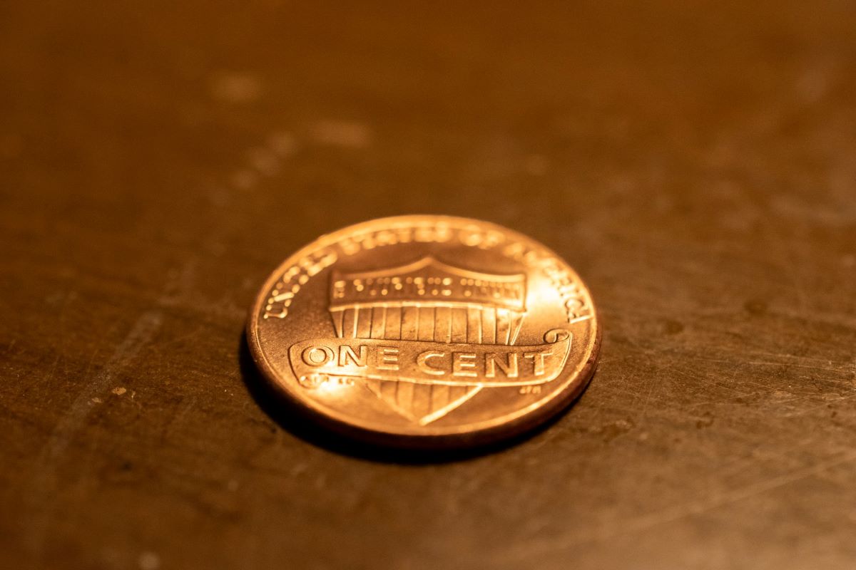 A single penny lying face-down on a table.