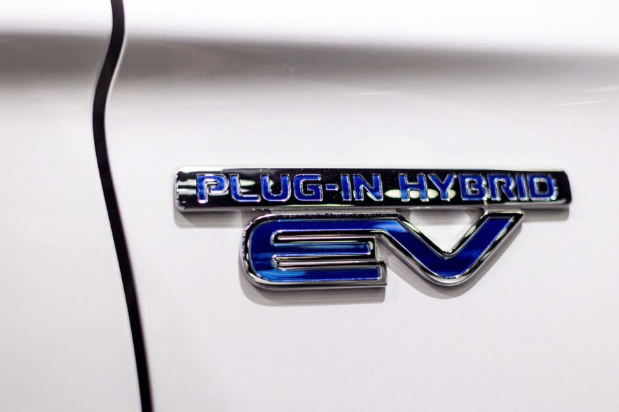 A plug-in hybrid EV badge on a Mitsubishi Outlander PHEV SUV