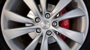 Close-up shot of a Tesla wheel, showing a red EV brake caliper