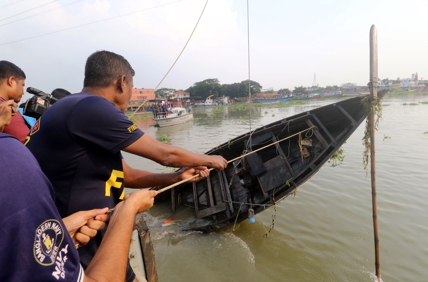 Rescuers retrieving a capsized trawler boat in the Turag river in Dhaka, Bangladesh