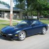 A blue 1993 Mazda RX-7 parked on the side of the street