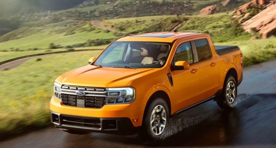 A yellow 2022 Ford Maverick small pickup truck is driving on the road.