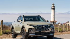 The 2022 Hyundai Santa Cruz compact pickup truck/sport adventure vehicle parked near a lighthouse