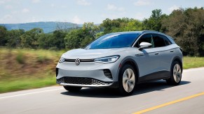 A light blue 2022 Volkswagen ID.4 driving down a road.