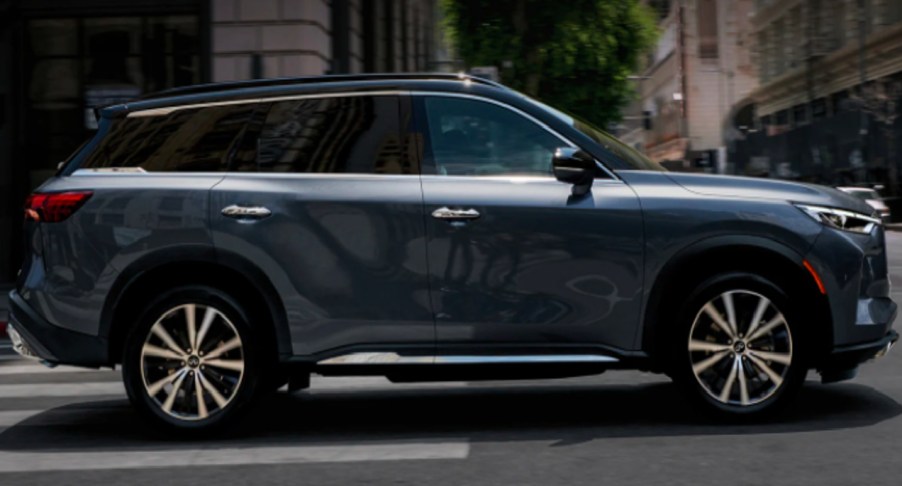 A gray 2022 Infiniti QX60 luxury SUV is driving on the road.