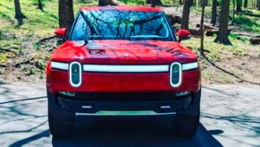 A red 2022 Rivian R1T Launch Edition electric pickup truck is pared on a sunny day.