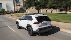 Rear view of 2022 Toyota RAV4 Off Road in white driving on a road